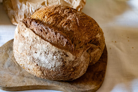Rustic Neapolitan farmer's sourdough loaf with whole grains on wooden board, traditional Italian baking artisanal techniques