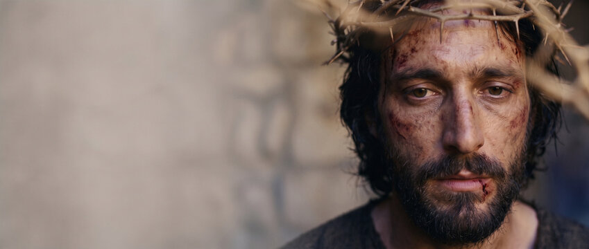 Face of the suffering servant. Man with crown of thorns representing the biblical sacrifice and passion of Jesus. Cinematic portrait of historical drama with copy space for religious theme.