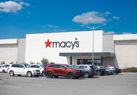 Macy's department store building facade with logo and parked cars in a parking lot under a blue sky in Philadelphia, Pennsylvania, United States, July 25, 2026