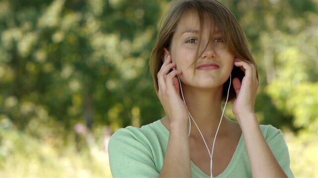 Young woman listening to music through headphones