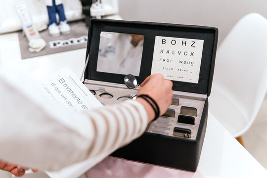 Woman examine eyeglass frame with portable vision test chart
