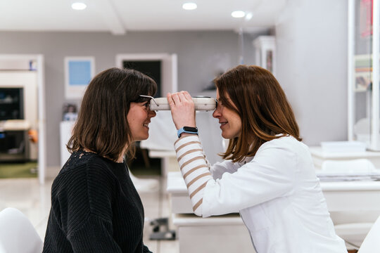 Optic woman examine patient vision in optical store