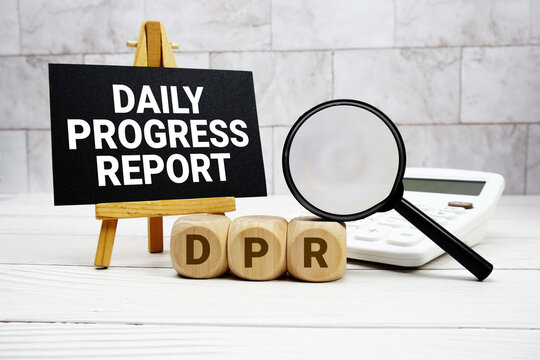 DPR Daily Progress Report text with calculator magnifying glass and on wooden background