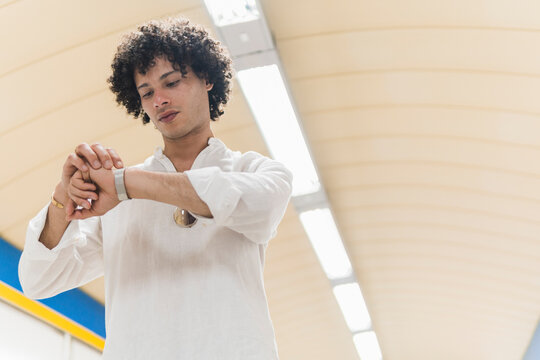Man check wristwatch in modern city transit station