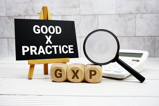 GXP Good x Practice text with calculator magnifying glass and on wooden background