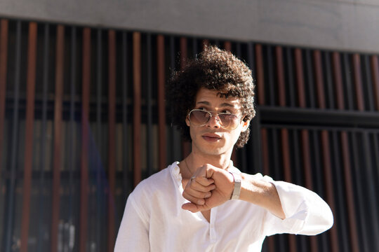 Man checking wristwatch in modern city architecture