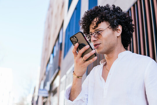 Man use smartphone for voice message in city street
