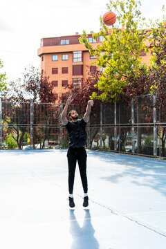 Man shoot basketball on outdoor urban court