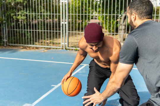 Friends play basketball on an outdoor court