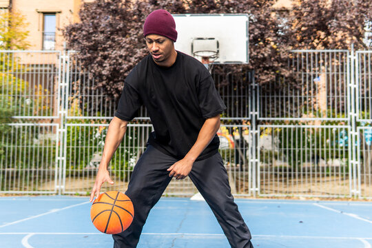 Man dribble basketball on outdoor court