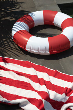 Red and white striped pool float on sunny patio