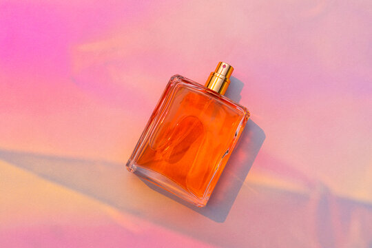 Orange perfume bottle mockup on bright pink background