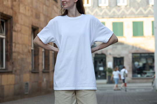 Woman wearing a plain white t-shirt and beige shorts outdoors