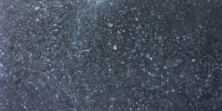 Dark charcoal terrazzo texture with blue stone chips, polished black granite surface, industrial concrete floor background for architectural design
