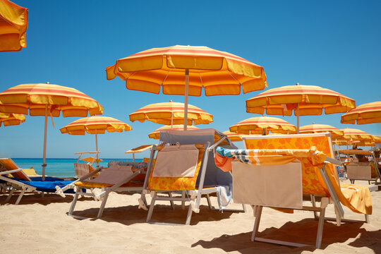 Orange beach umbrellas and sunbeds on Sicily coast