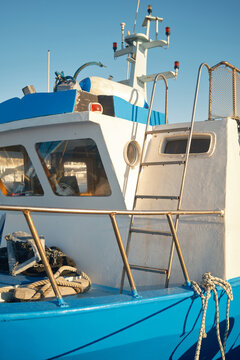 Blue and white fishing boat deck with rope in Favignana