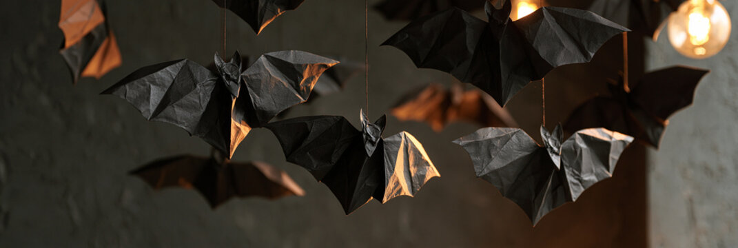 Hanging origami bats in a dimly lit setting create a spooky atmosphere.