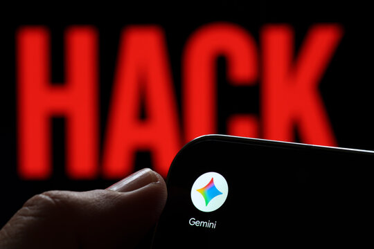 Google Gemini app logo shown on a smartphone held in hand against a red HACK warning in an AI security concept. Stafford, United Kingdom, August 2, 2026.