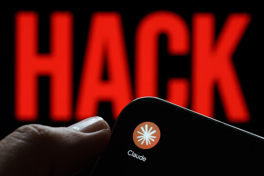 Claude app logo shown on a smartphone held in hand against a red HACK warning in an AI security concept. Stafford, United Kingdom, August 2, 2026.