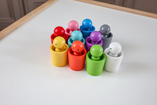 Colorful Montessori color sorting toy with wooden figures arranged on a children's table in a modern playroom.