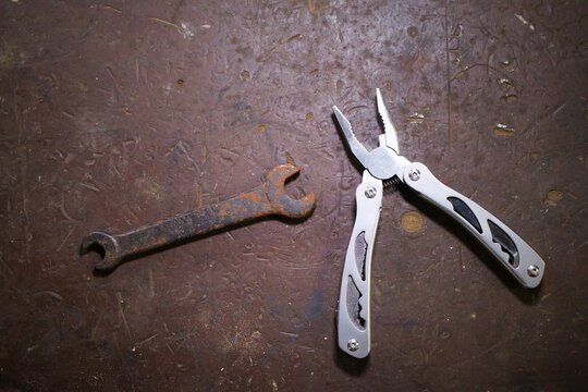 old rusty wrench and modern multitool 