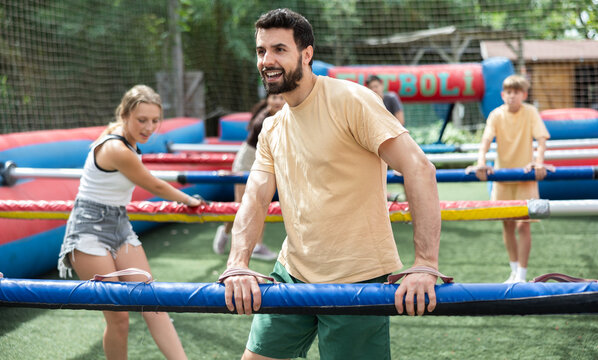 Friends play kicker, live football game, at an amusement park on a summer day
