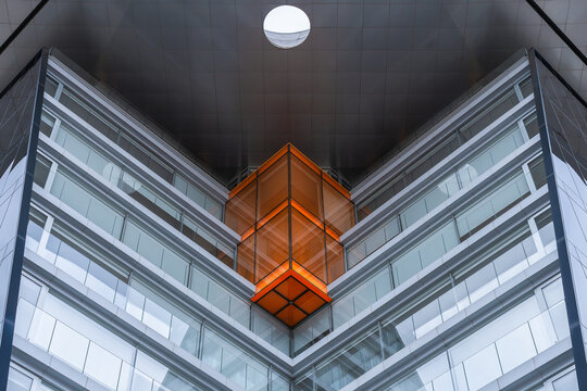 Modern glass facade detail with bold orange geometric cube