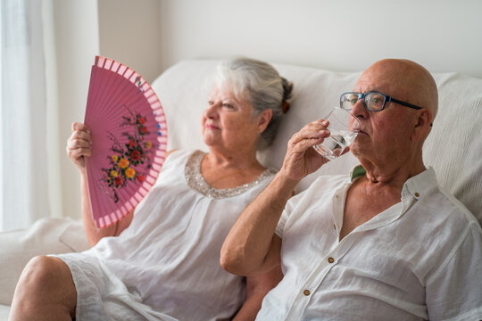 Senior couple manage extreme heat with water and fan