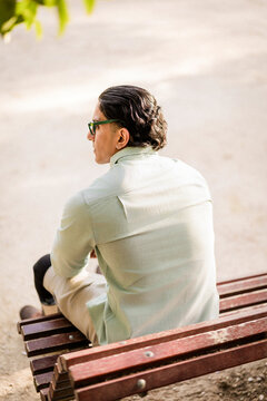 Latino man with prosthetic legs sitting outdoors