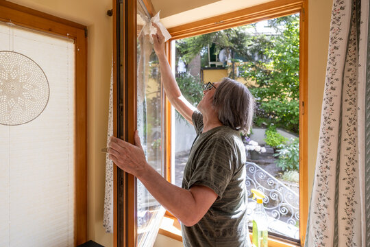 Mature man clean apartment window with paper towel