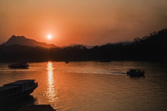Sunset over the Mekong River in Laos with boats