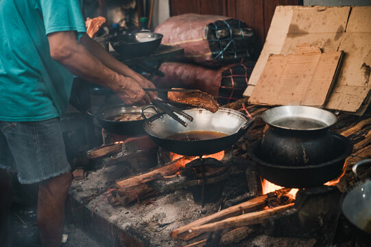 Cook prepare traditional Lao street food over open fire
