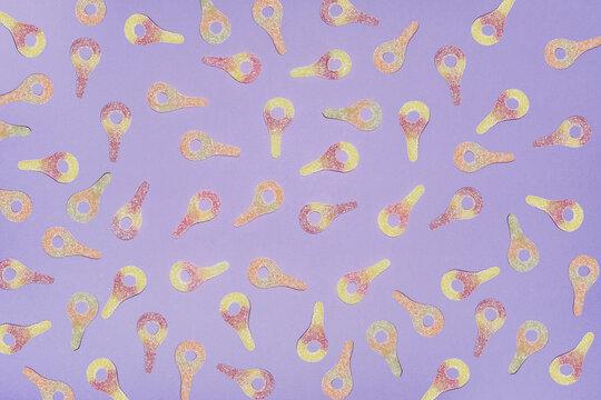 Colorful sweet and sour candy pattern on purple background