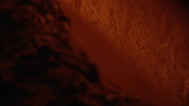 Macro view of rich, aromatic cinnamon powder gently sifting through the air, highlighting the fine, granular texture and deep, warm, reddish brown color in a slow and continuous fall