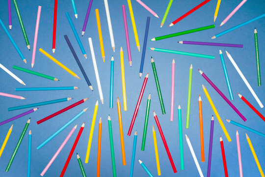 Colorful pencil pattern scattered on blue background