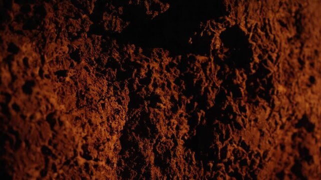 Close up view of dark, fertile soil showcasing its rough, organic texture and mineral composition. Ideal background for agriculture, farming, or environmental concepts with natural lighting
