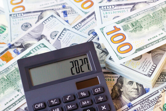 A black color calculator 2027 year written on it and designed with US dolar banknotes.Above view 