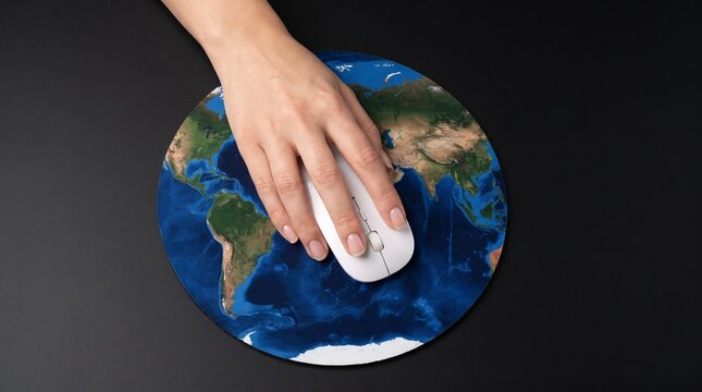 Hand using a computer mouse on a circular world map mousepad