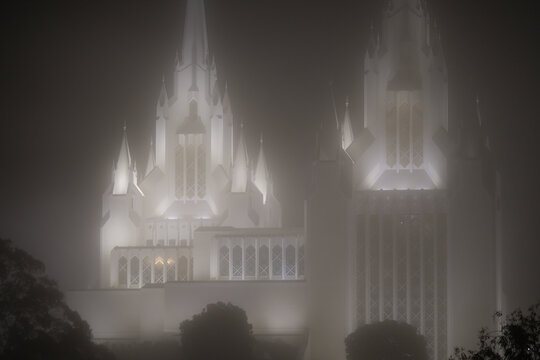 A close-up view of an architectural marvel shrouded in fog reflects a minimalist aesthetic, where form and light interplay, evoking emotions of curiosity and introspection.
