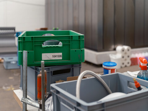 A parts crate, bar clamp and cleaning supplies on a bench in a module production workshop.