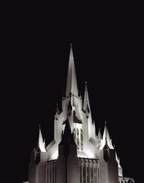 A striking image of a beautifully designed church tower illuminated against the dark night sky, symbolizing faith, spirituality, and architectural grandeur.