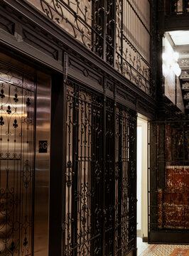 Showcasing a beautifully preserved vintage building interior, featuring ornate elevator gates and decorative architectural details that reflect historical significance and elegance.
