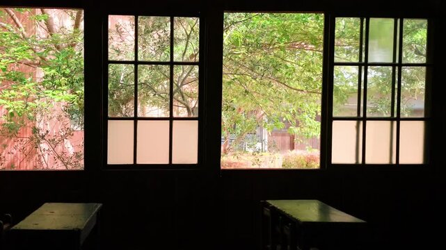 風が吹き込む学校の窓と緑の木々　夏の教育風景