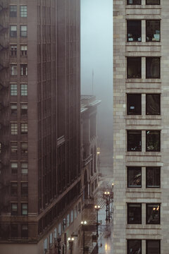 A captivating cityscape that showcases tall buildings shrouded in fog, enhancing the sense of mystery and atmosphere in an urban environment during rainy weather.