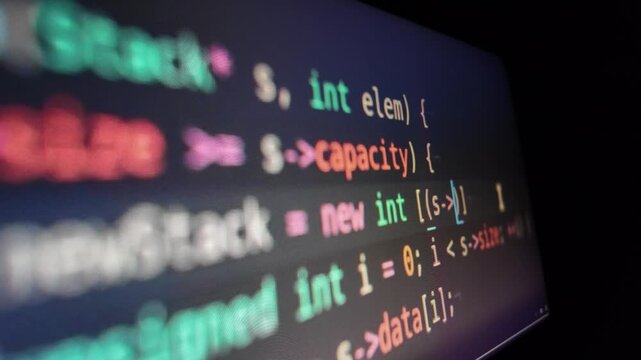 Computer monitor displays lines of syntax highlighted code in dark mode, symbolizing AI software development, vibe coding, and machine learning.