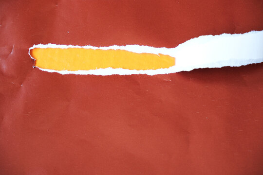 Torn paper with space for text on an orange background. The torn brown paper peels away to reveal the orange paper underneath.