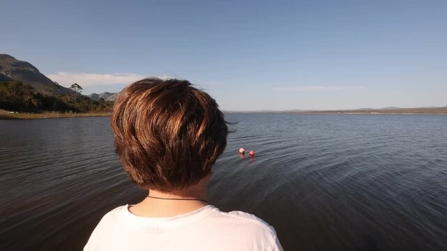 rear view of boy looking out at Grotto Lagoon, Hermanus, South Africa