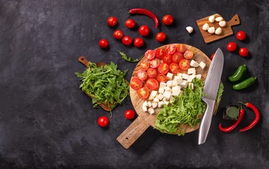 Top view of salad ingredients with mozzarella cheese, tomatoes and herbs on a wooden chopping board, flat lay, horizontal banner with space for text © rustamank