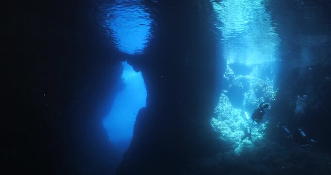 cave diving underwater scuba divers exploring caves and having fun ocean scenery sun beams and rays background