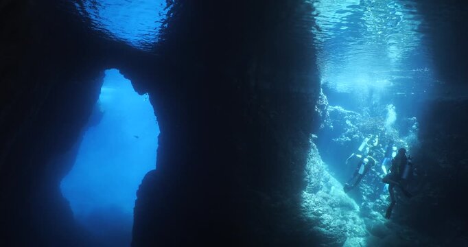 cave diving underwater scuba divers exploring caves and having fun ocean scenery sun beams and rays background